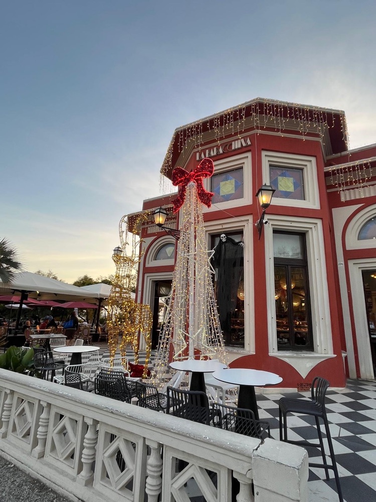 Albero di Natale illuminato davanti a un caffè sul lungomare